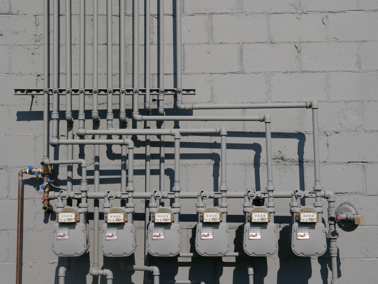 Crafting Captivating Headlines: Your awesome post title goes here Row of gas meters and piping mounted on a concrete wall, illustrating urban utilities.